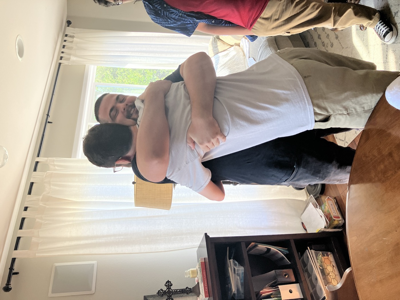 Two friends from the online community embracing in a big hug when meeting in person