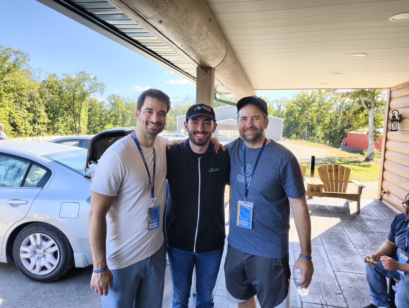 Three friends smiling together on the porch at HopeCon