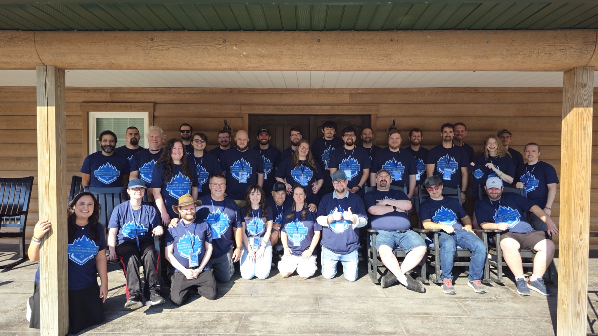 The whole HopeCon group gathered on the porch of a log lodge