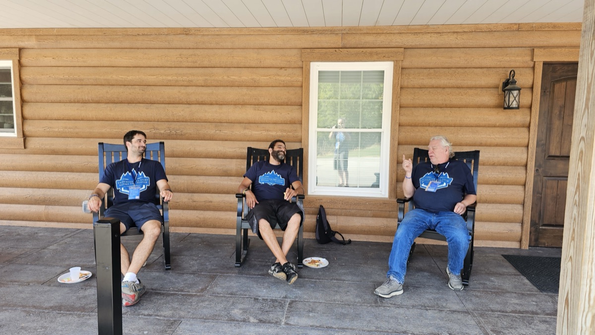 Friends talking together in rocking chairs on a cabin porch
