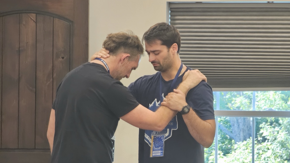 Two men praying for one another
