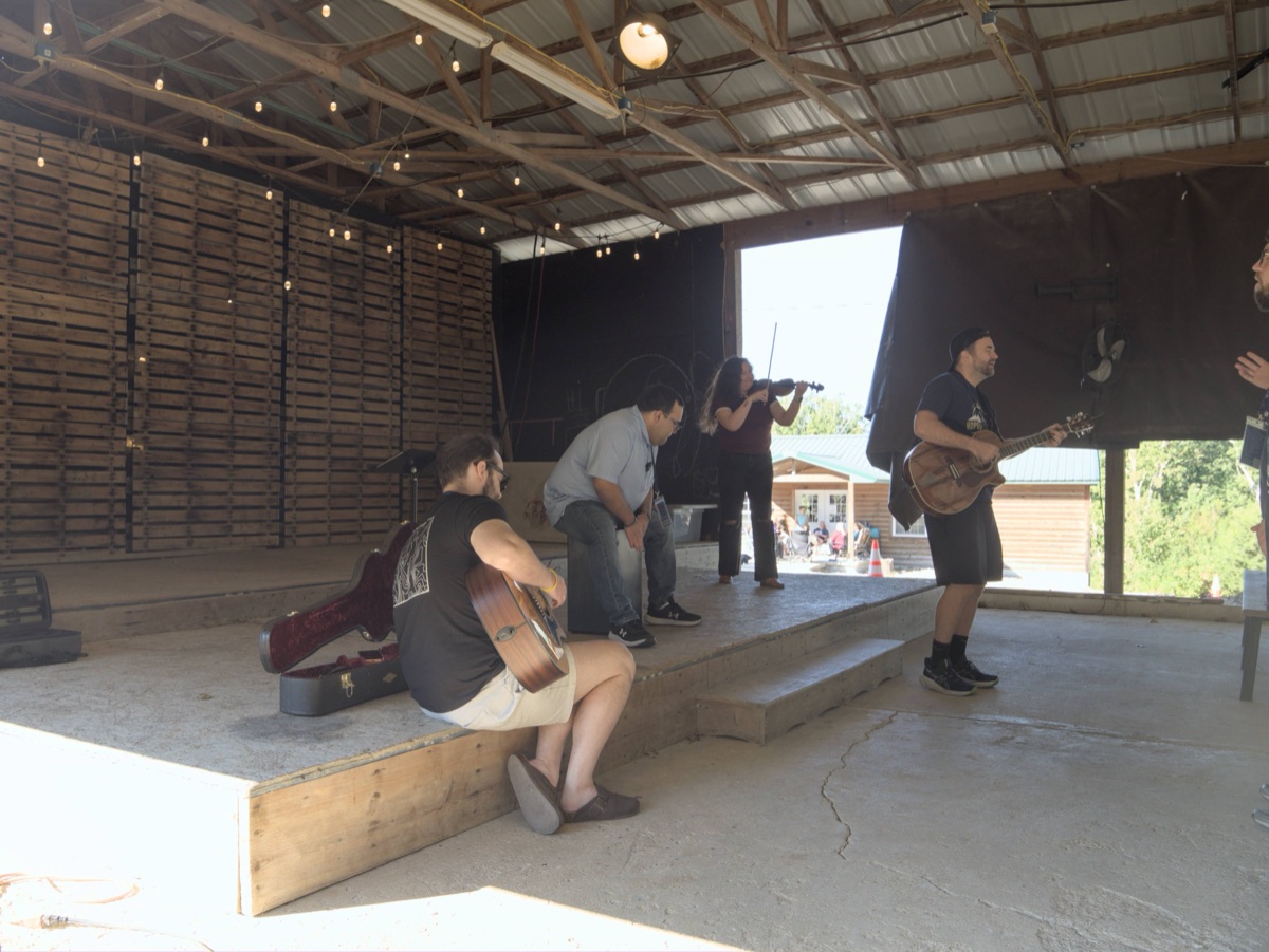 Musicians leading worship in an open-air pavilion
