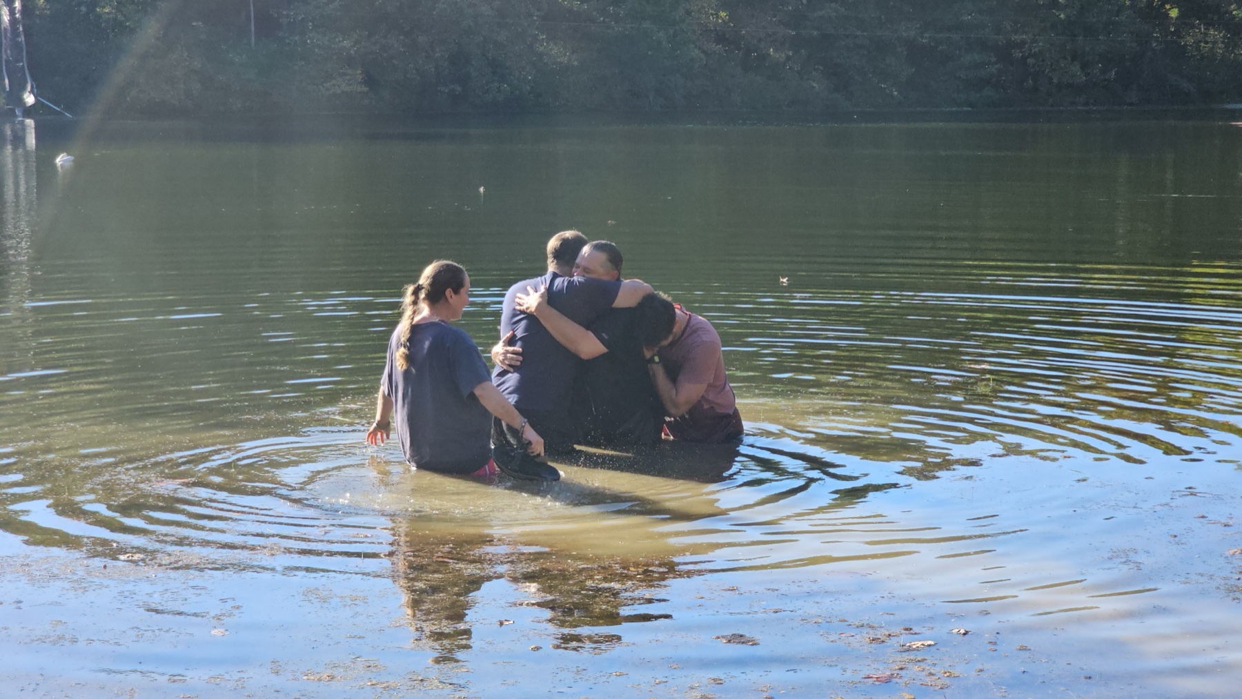 Troy embraced in the lake moments after his baptism